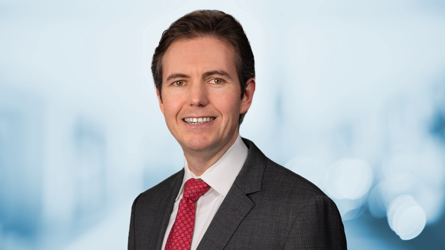 Headshot of Stephen Stewart on blue background.