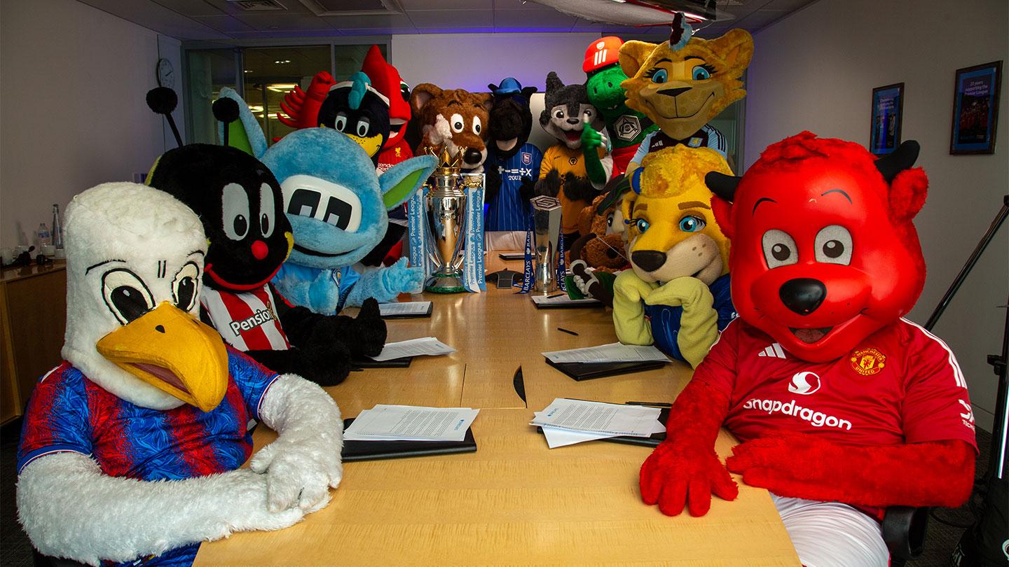 Various football mascots sat around a desk