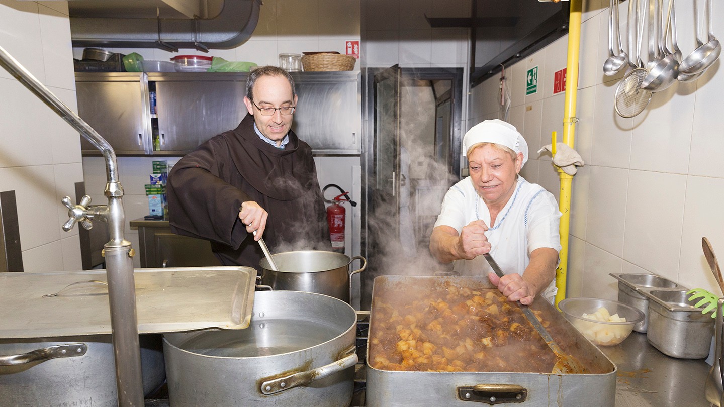 Carlo Cavallari and volunteer cook Maria Giovanna Condello preparing food in the kitchen