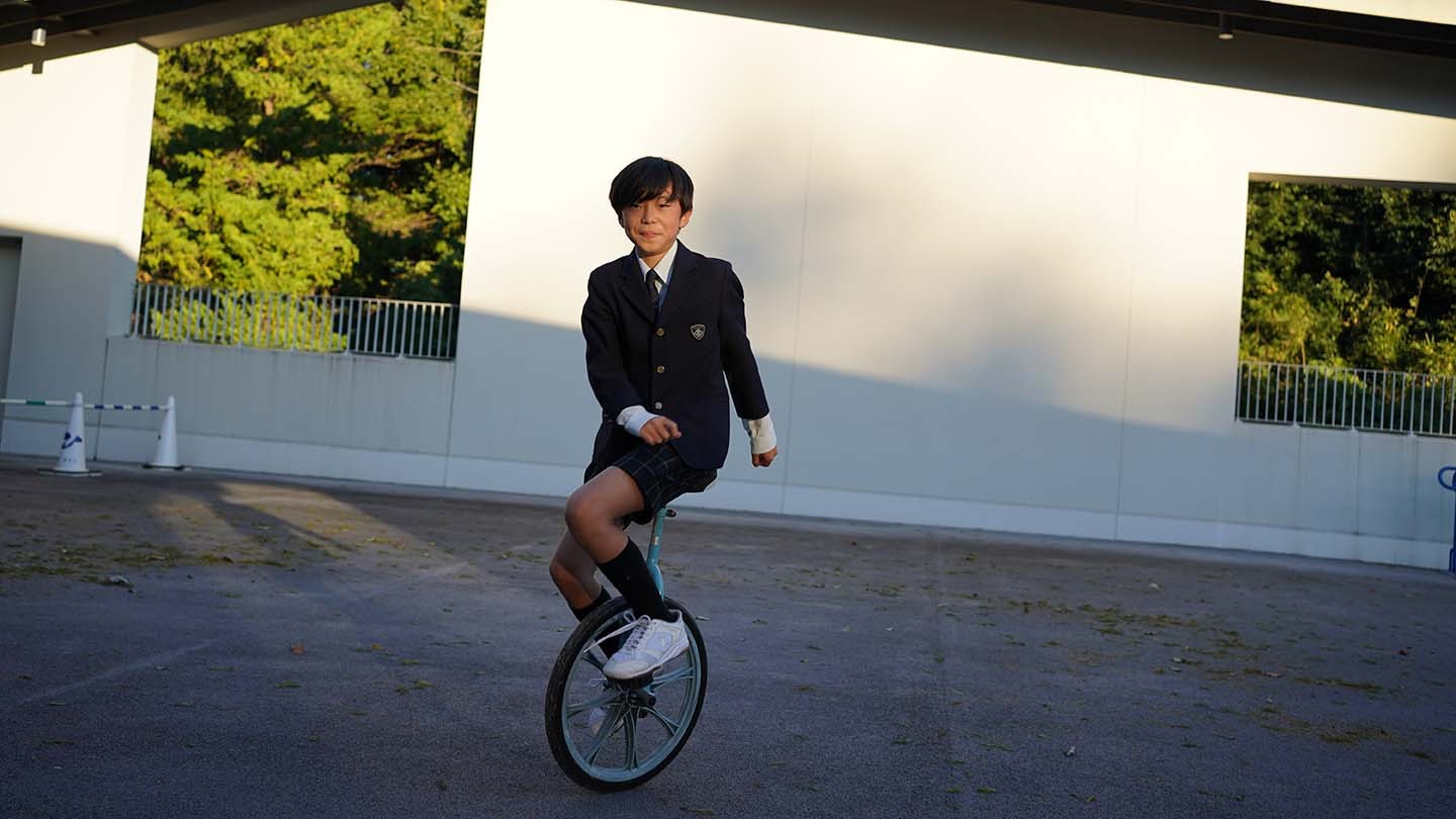 Hayato rides a unicycle.