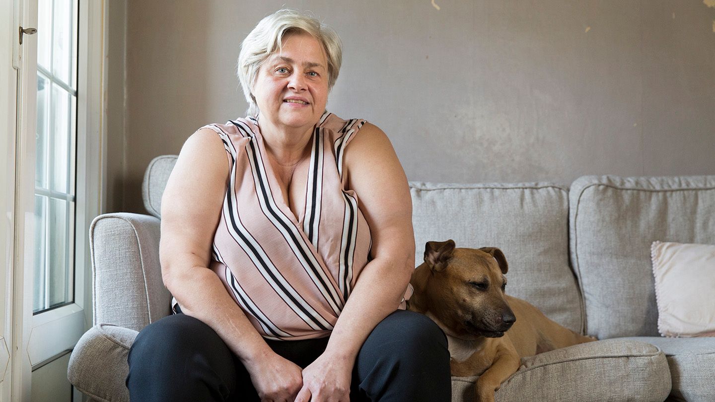 Nicola sitting on her couch with her dog.