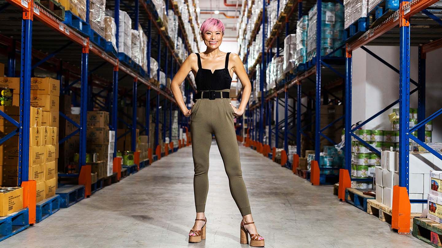 Nichol Ng poses for a photo in a large warehouse.