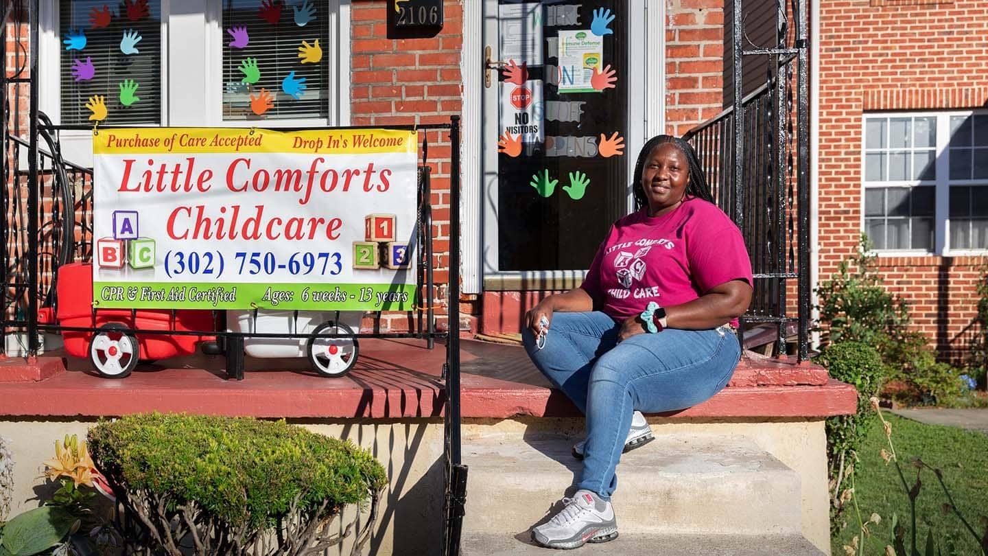 Tina Thomas sits in front of her business, Little Comforts Childcare.