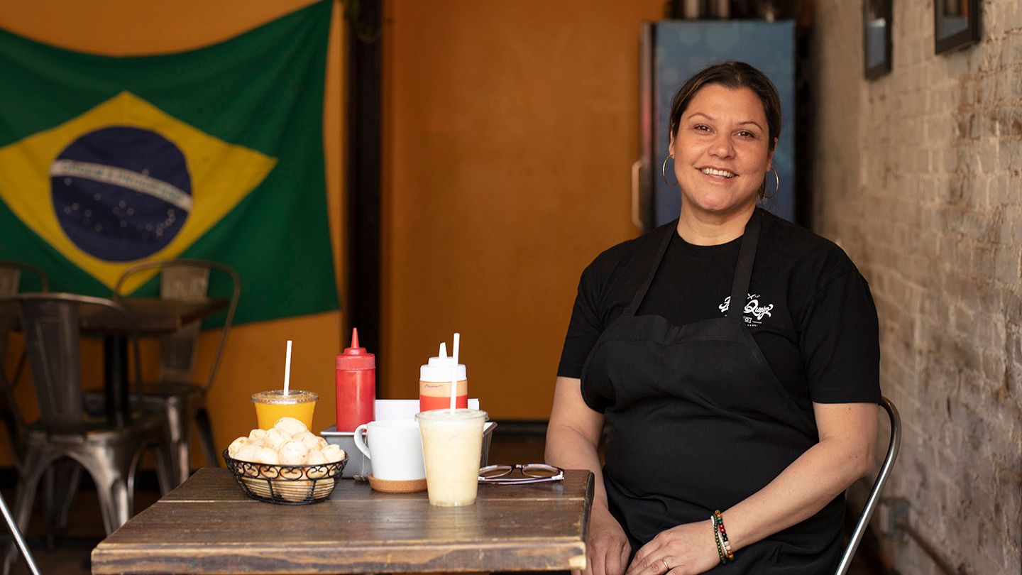 Karina Guimaraes sits at a table in her restaurant, Pao de Queijo