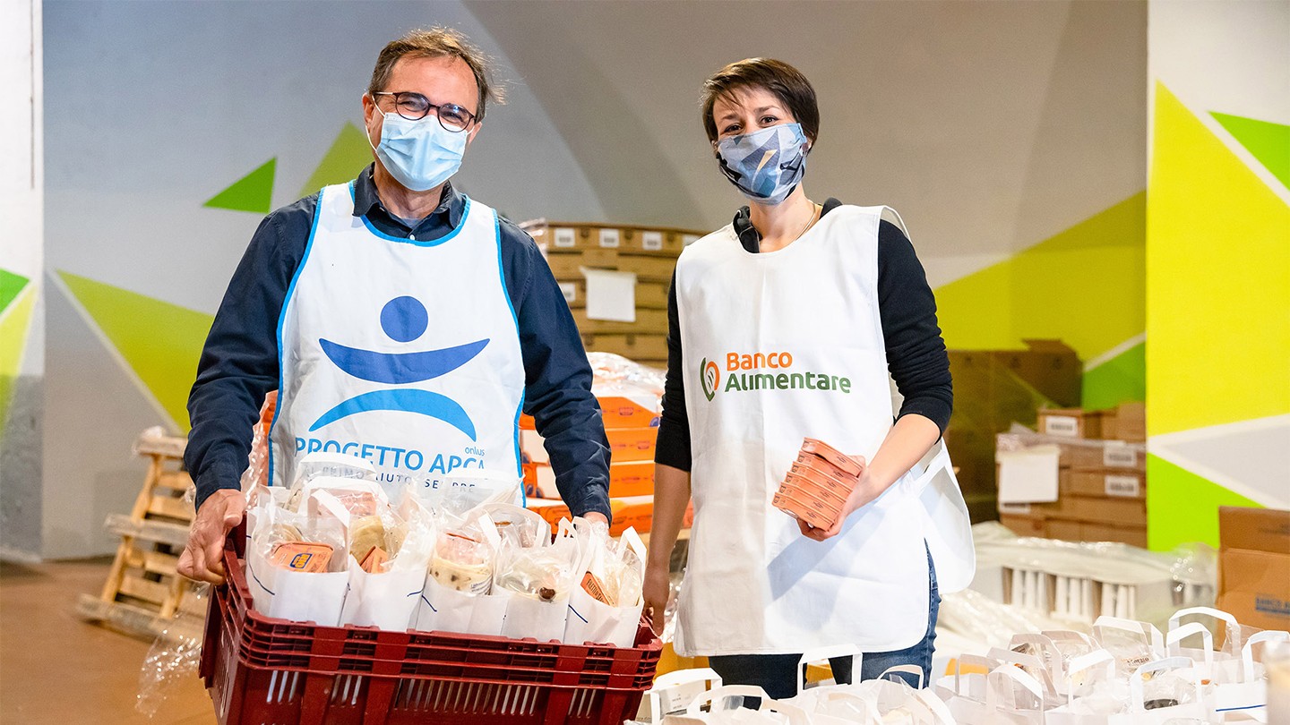 Two Banco Alimentare volunteers holding food parcels