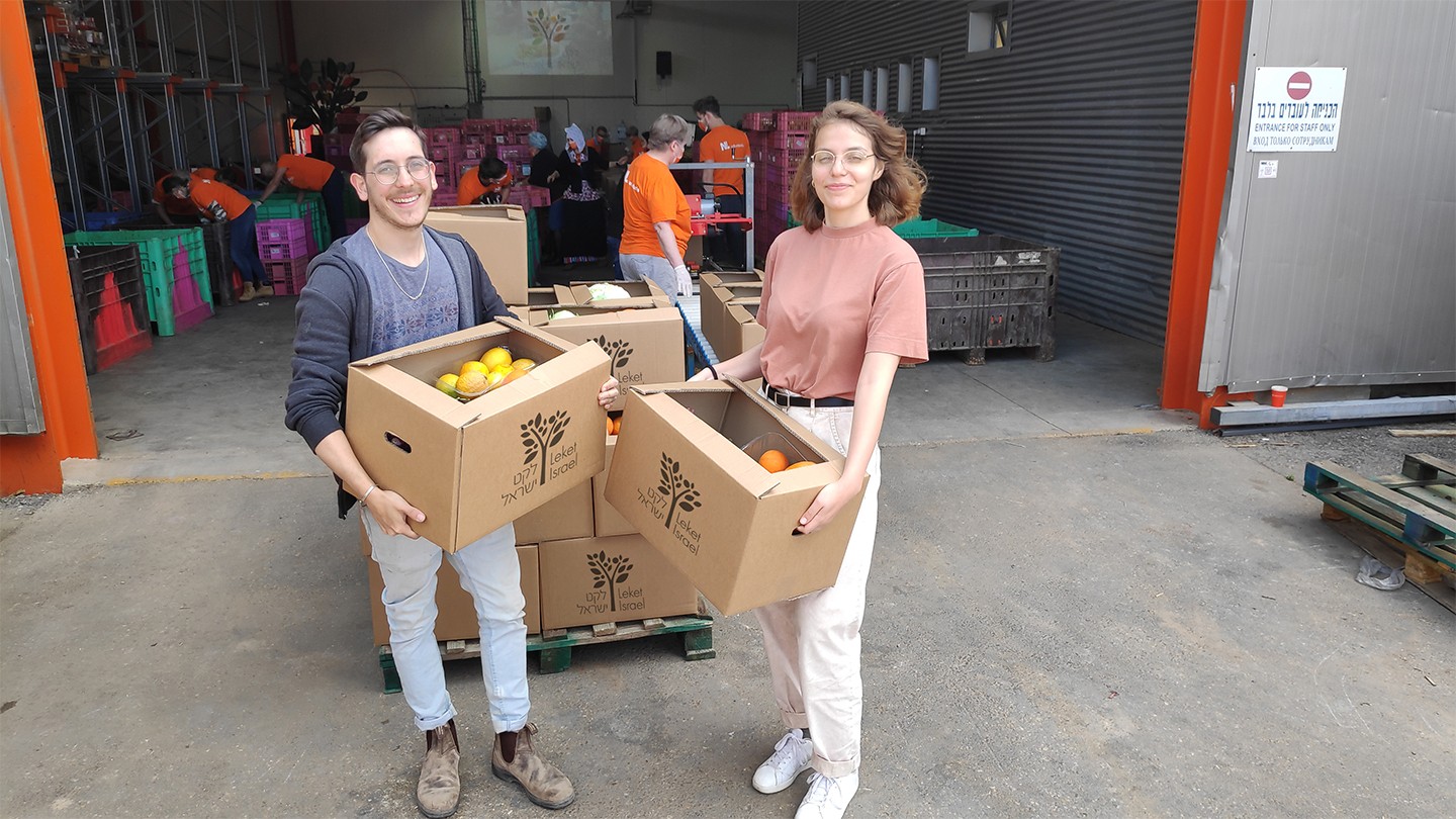 Leket Israel volunteers holding boxes of food
