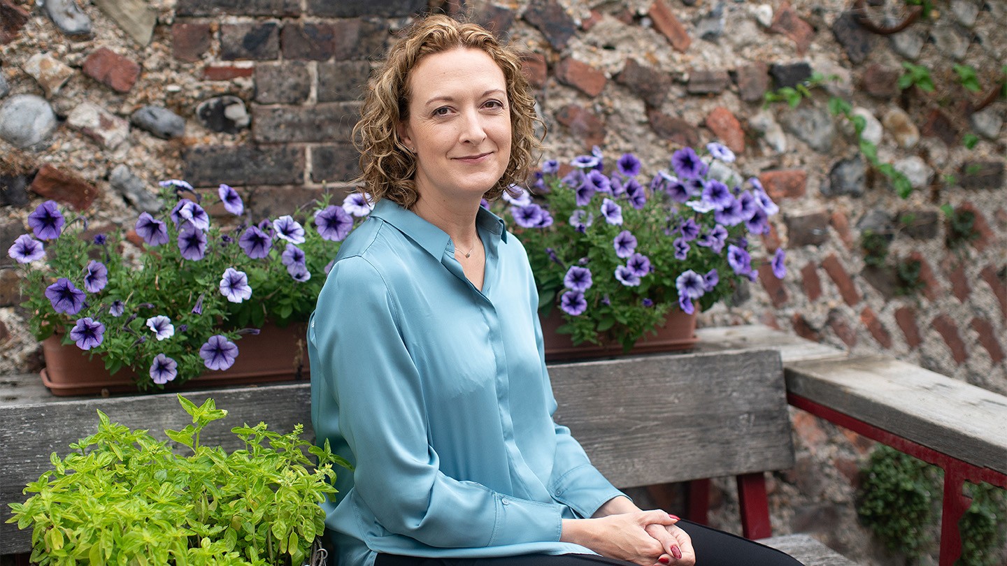 Barclays Business Banking’s Hannah Bernard sits on a bench in a garden.