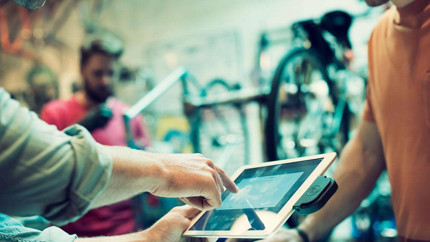 A member of staff in a bike shop takes digital payment. 