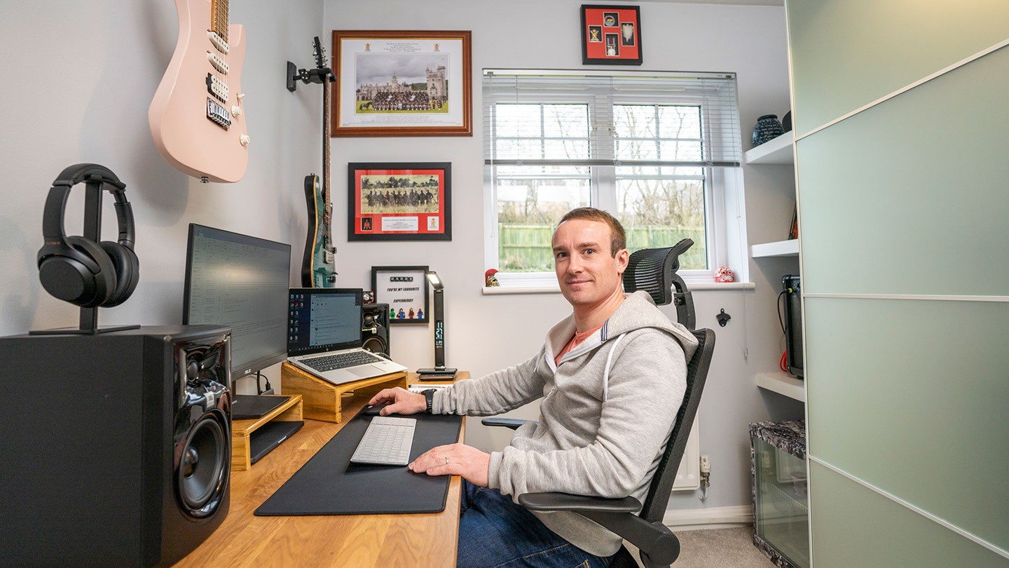 Barclays’ Lewis Taylor sitting at his home office desk. 
