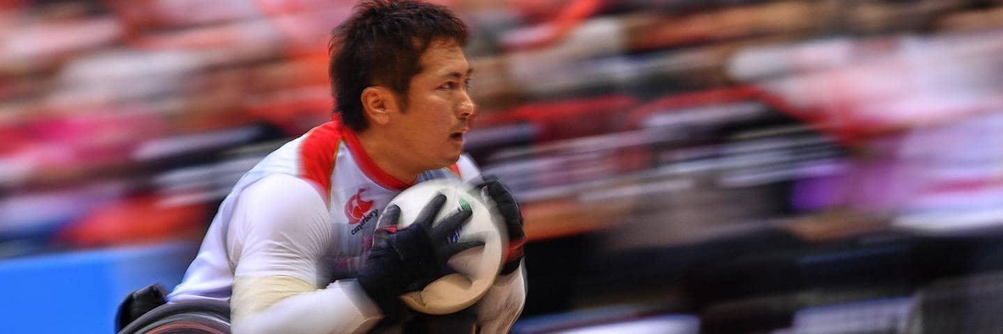 Shinichi Shimakawa races across a wheelchair rugby court at a Paralympic competition.