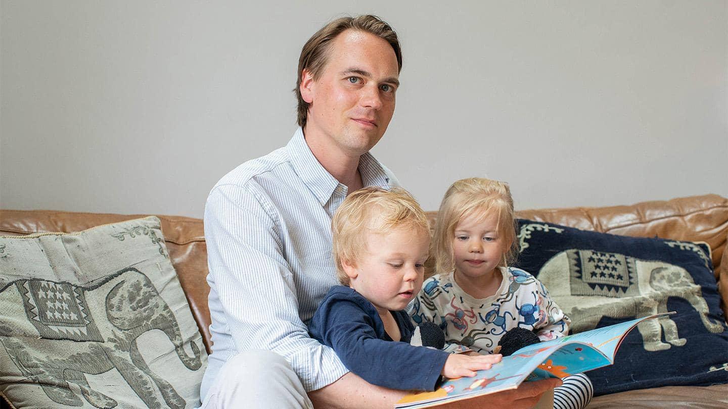 Barclays’ Gavin Westmoreland sits with his young twins, reading a children’s book.