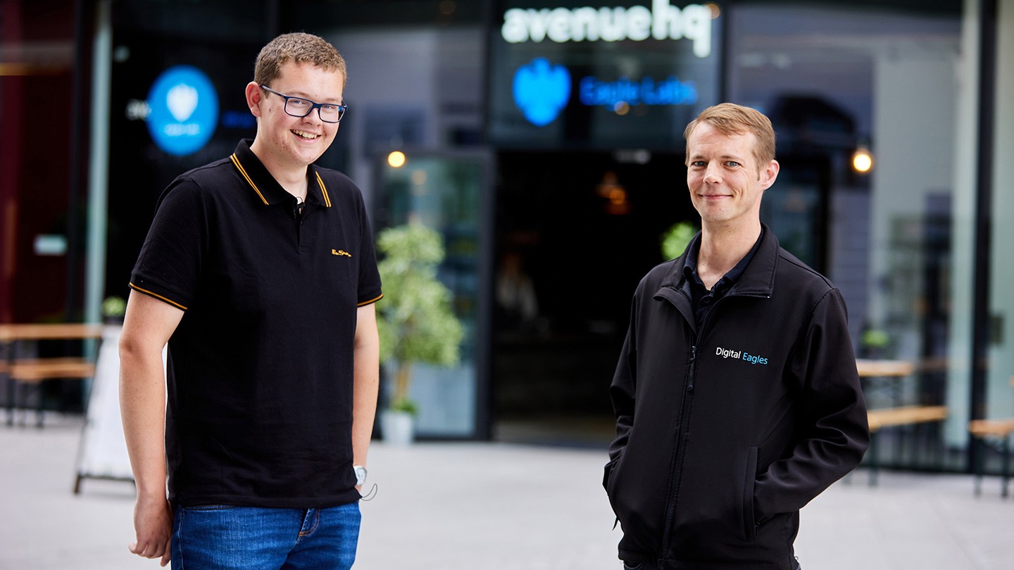 Kevin and James stand together in front of a Barclays Eagle Labs building.