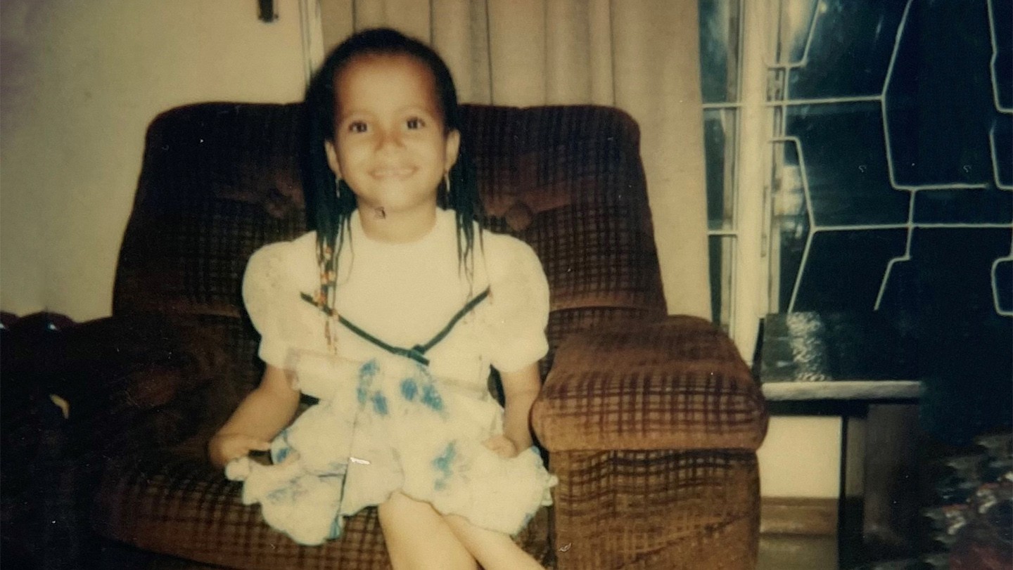 Six-year-old Sian sits on a large armchair. 