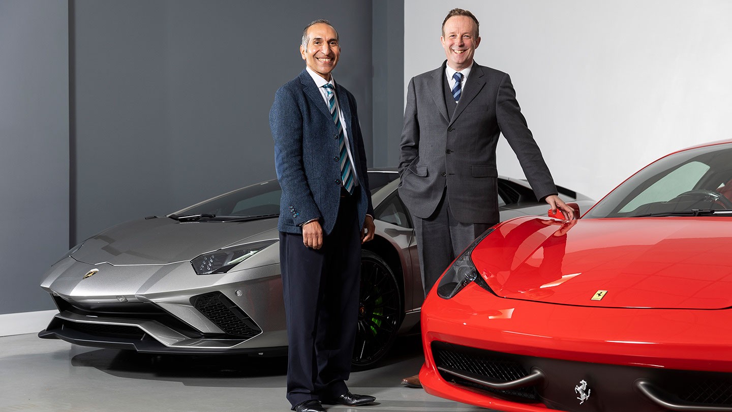 Narinder Dhandwar and his client Pete Johnson, from The Car Company, standing by two sports cars.